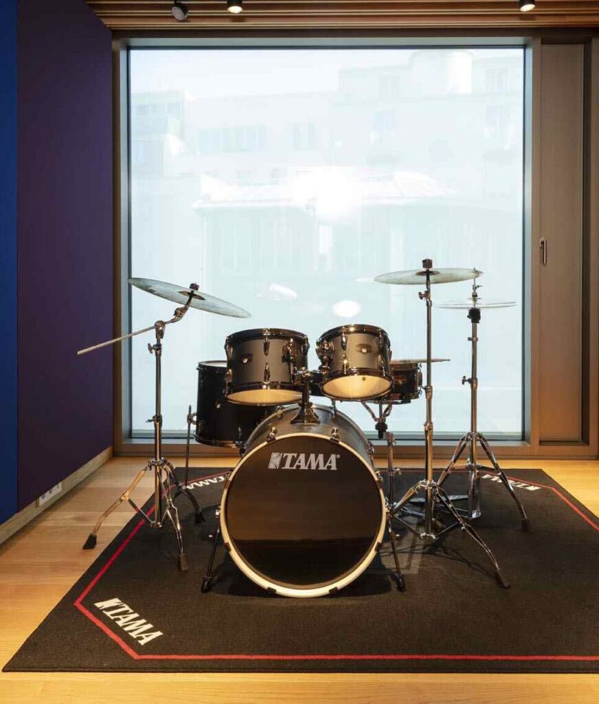 Schlagzeugraum in Raum 5 im Haus für Musik Potsdam mit Schlagzeug, Notenständer, Tisch und Stuhl für Probe, Unterricht und Gesangsbegleitung.