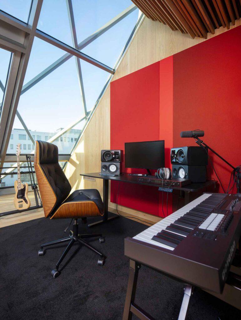 Ausstattung von Raum 9 im Haus für Musik Potsdam mit Mikrofonen, Lautsprechern, Keyboard, Audiointerface sowie E-Gitarre und Bass für Recording- und Podcast-Aufnahmen.